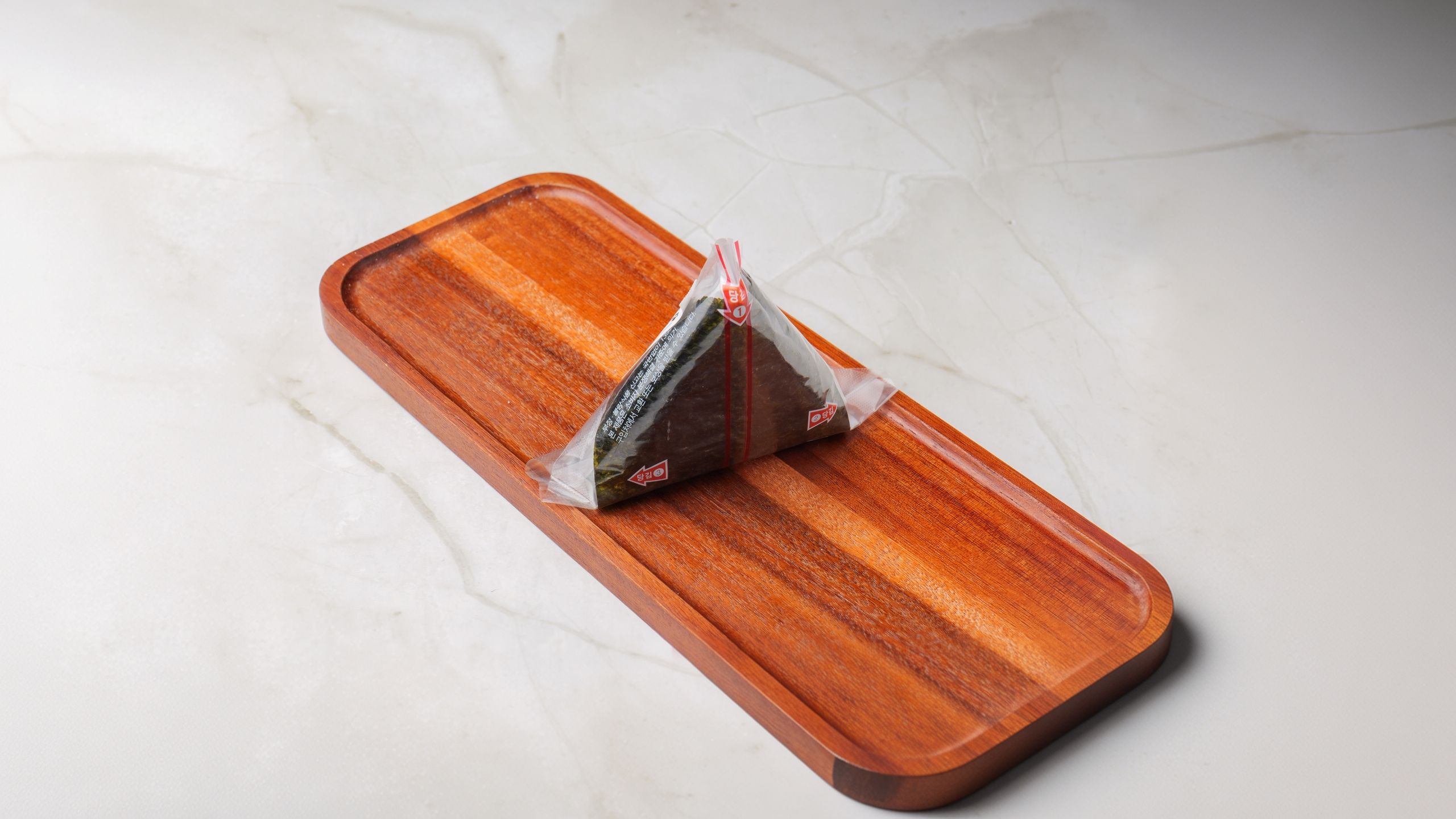 Onigiri wrapped and served on a wooden tray